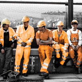 wartende Bauarbeiter Gruppe Swietelsky orange arbeitshosen und gelbe helme hauptbahnhof wien