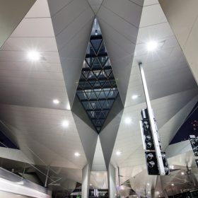 Wien Hauptbahnhof bei Nacht blick aufs Rautendach mit Beleuchtung von unten mit ausfahrendem Zug